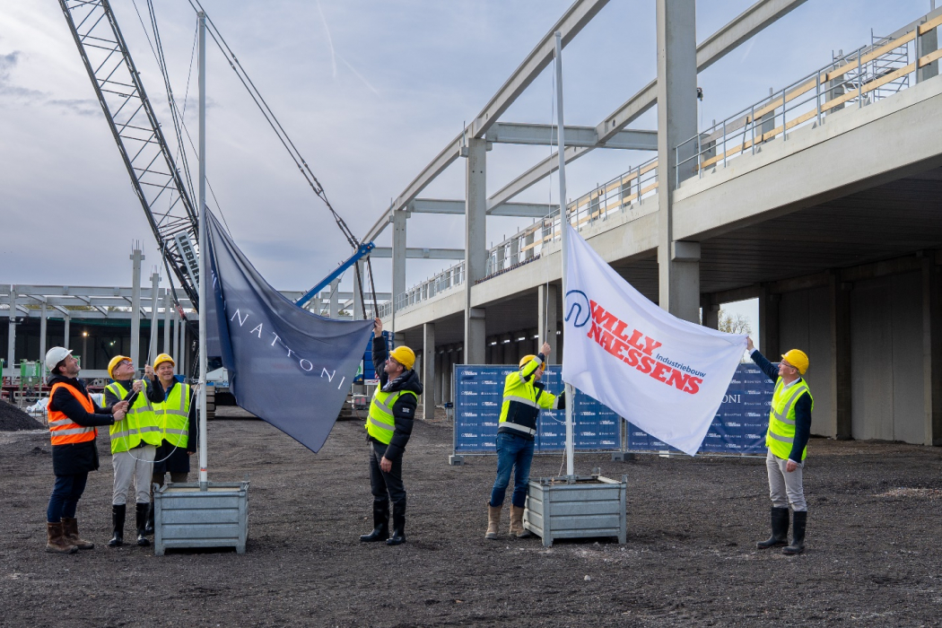 De afgevaardigden van Panattoni en Willy Naessens hijsen de vlag op het bouwterrein van Panattoni Park Sas van Gent.