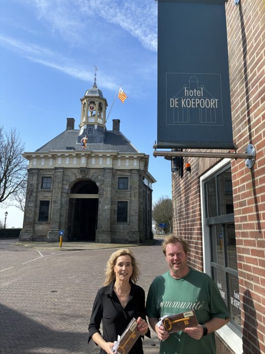 Verkoopster en koper naast het hotel en voor Stadspoort “De Koepoort”.