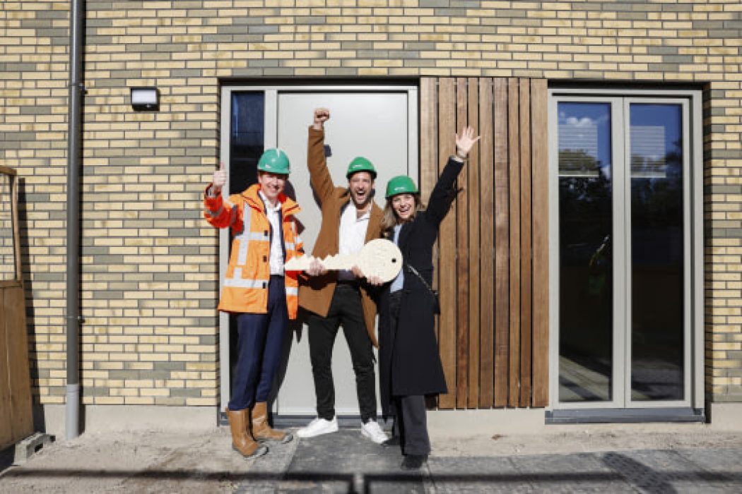 Paulien Huvers en Roland Goossens ontvangen de sleutel van Maarten Strijdonk, directeur BAM Wonen.