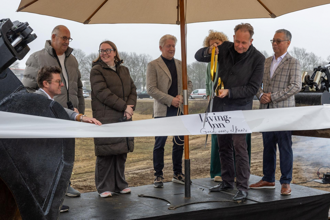 Symbolisch moment start bouw: wethouder Noël Vergunst knipt lint door.